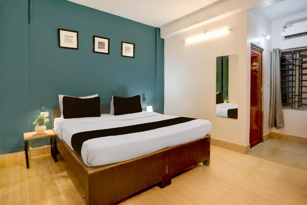 Collection O KIIT Square Bhubaneswar Formerly Nilay Classic في Bārang: غرفة نوم بسرير كبير وجدار أزرق