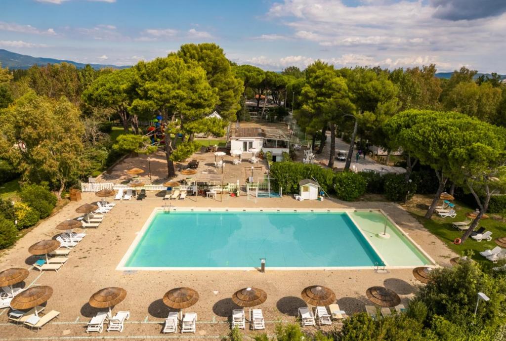 - une vue sur une piscine avec des chaises et un complexe dans l'établissement Camping Village Costa Est, à Riotorto