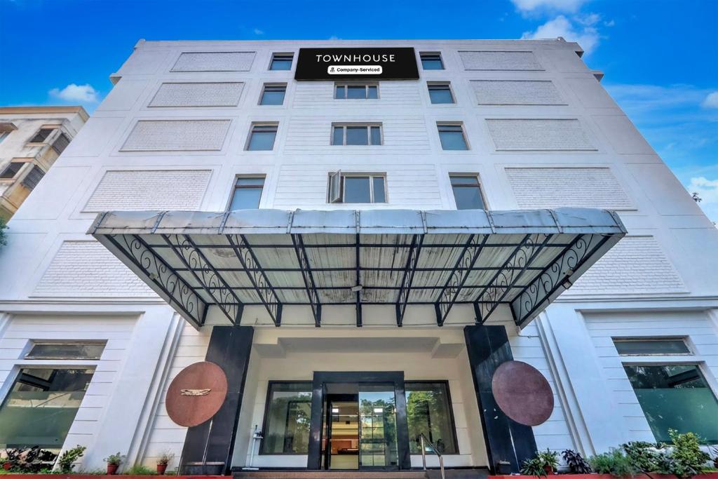 a white building with a sign on it at Townhouse Kakinada Nagamalli Thota Junction in Kākināda