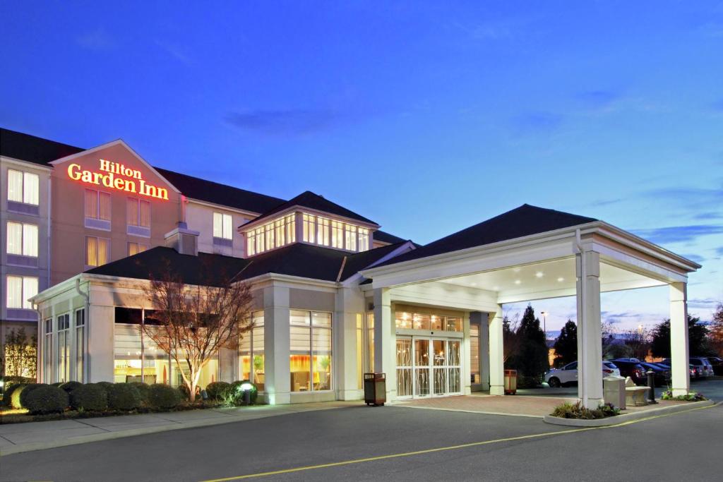 Hilton Garden Inn Chesapeake Greenbrier في تشيسابيك: فندق بمواقف السيارات امام مبنى