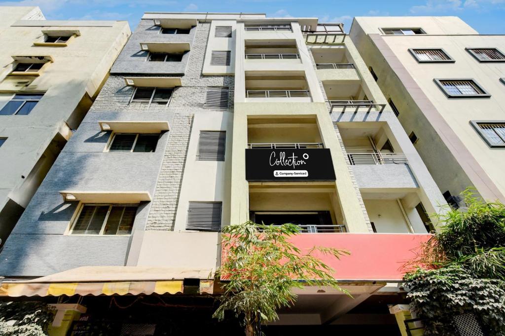 a tall white building with a black sign on it at Collection O Hyderabad Hitech City Formerly Night Eye in Hyderabad