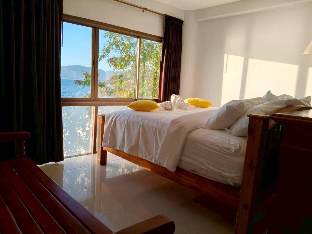 a bedroom with a bed with a view of the ocean at Jansom Beach Resort in Ranong