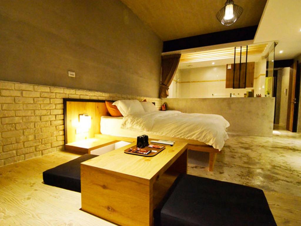 a bedroom with a bed and a table in it at Hotian Inn in Donggang