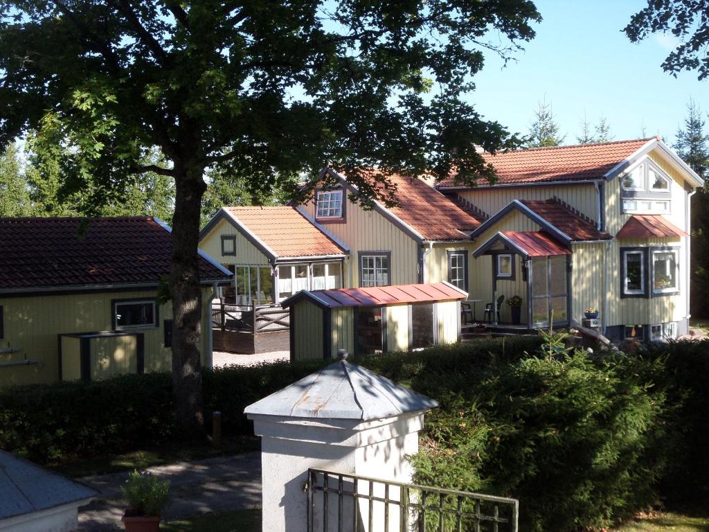 a row of houses with a fence and a tree at Skogis Bed & Breakfast in Katrineholm