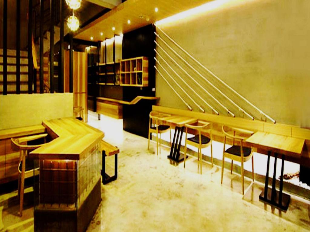 a restaurant with wooden tables and chairs in a room at Hotian Inn in Donggang