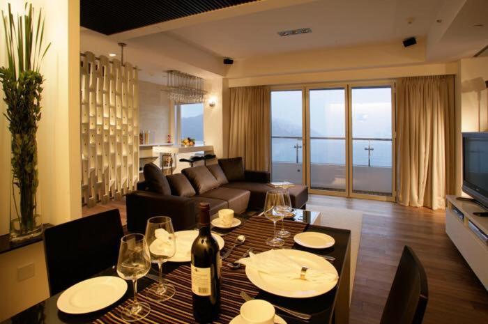 una sala de estar con una mesa con copas de vino en Stanley Oriental Hotel, en Hong Kong