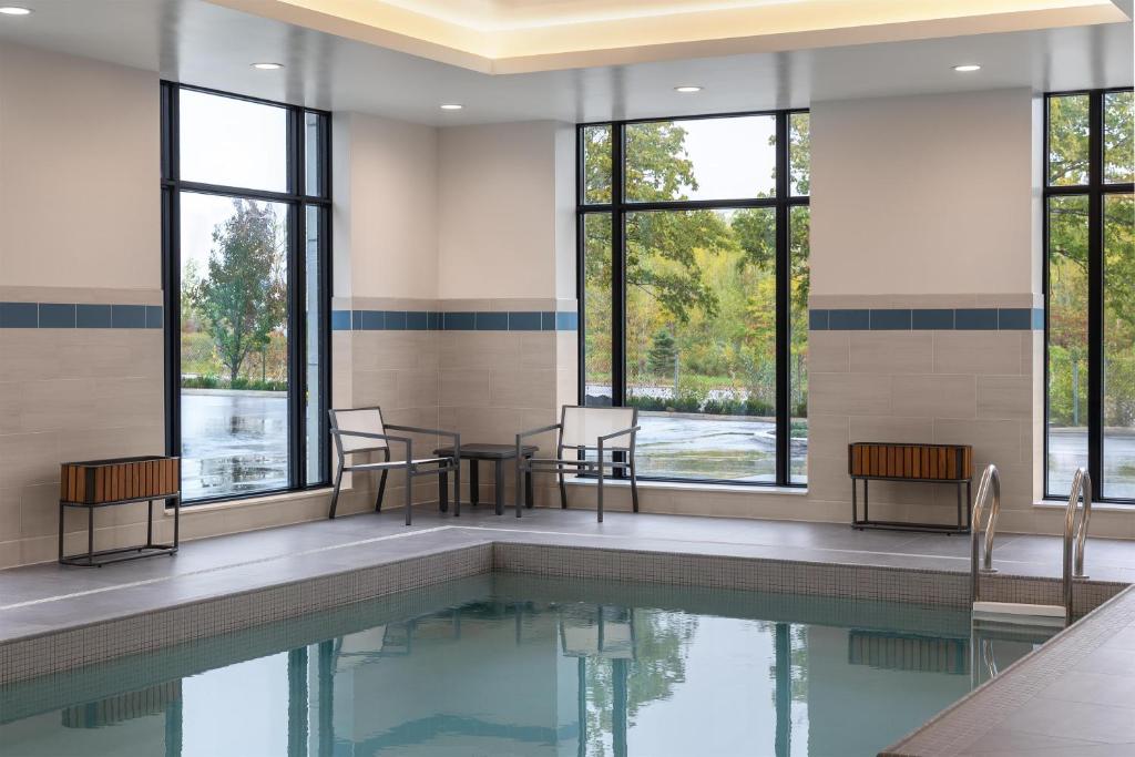 a pool with chairs and tables and windows at Hyatt Place Toronto Airport in Toronto