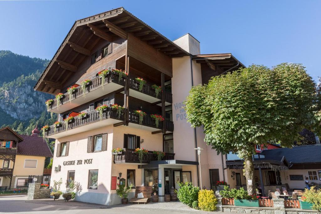 un gran edificio con macetas en los balcones en Hotel Zur Post en Döbriach