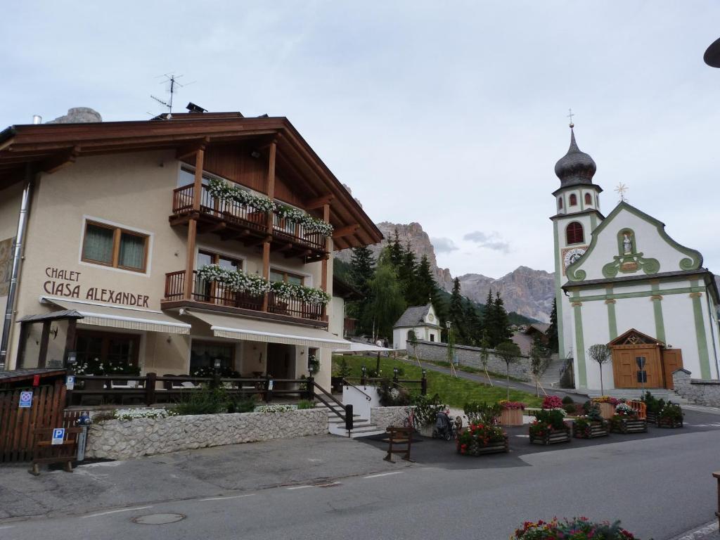 a building with a clock tower and a church at Chalet Ciasa Alexander in San Cassiano