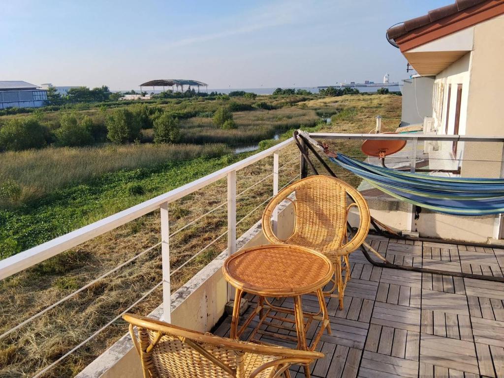 a porch with two chairs and a hammock on it at Jonah By The Sea Hideaway Cabin in Ban Sam Maitri