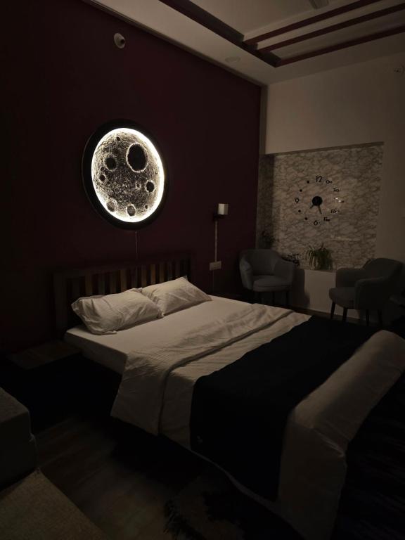 a bedroom with a bed with a moon picture on the wall at Kassy homestay in Udaipur