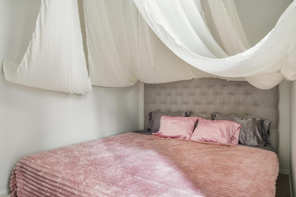 a bedroom with a bed with pink pillows at Private Studio Apt with Best Location in Helsinki