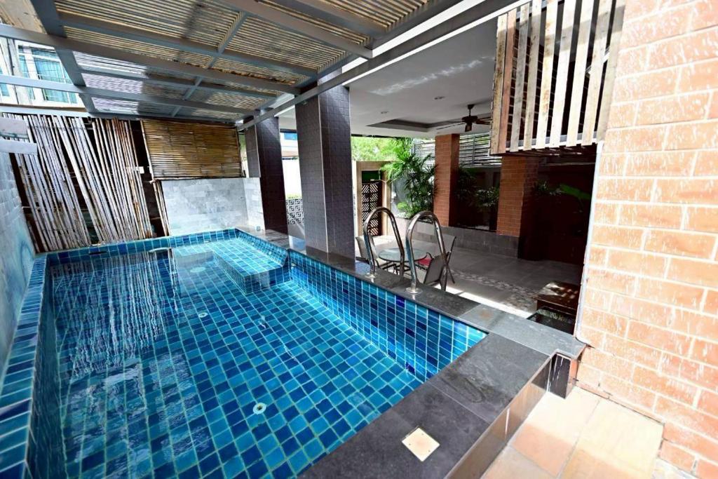 - une piscine revêtue de carrelage bleu dans l'établissement Fiscus Villa 3 bedrooms with private pool., à Pattaya (sud)
