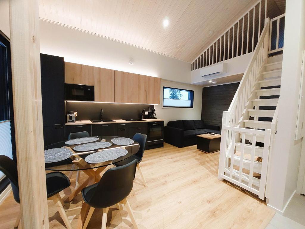 a living room with a table and chairs and a kitchen at Saarimaja in Syöte
