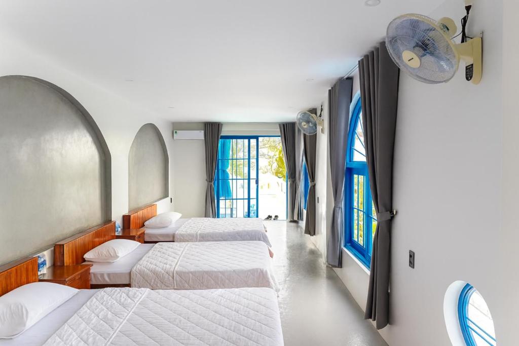 a row of beds in a room with windows at KParis Beach Resort in Bình Sơn