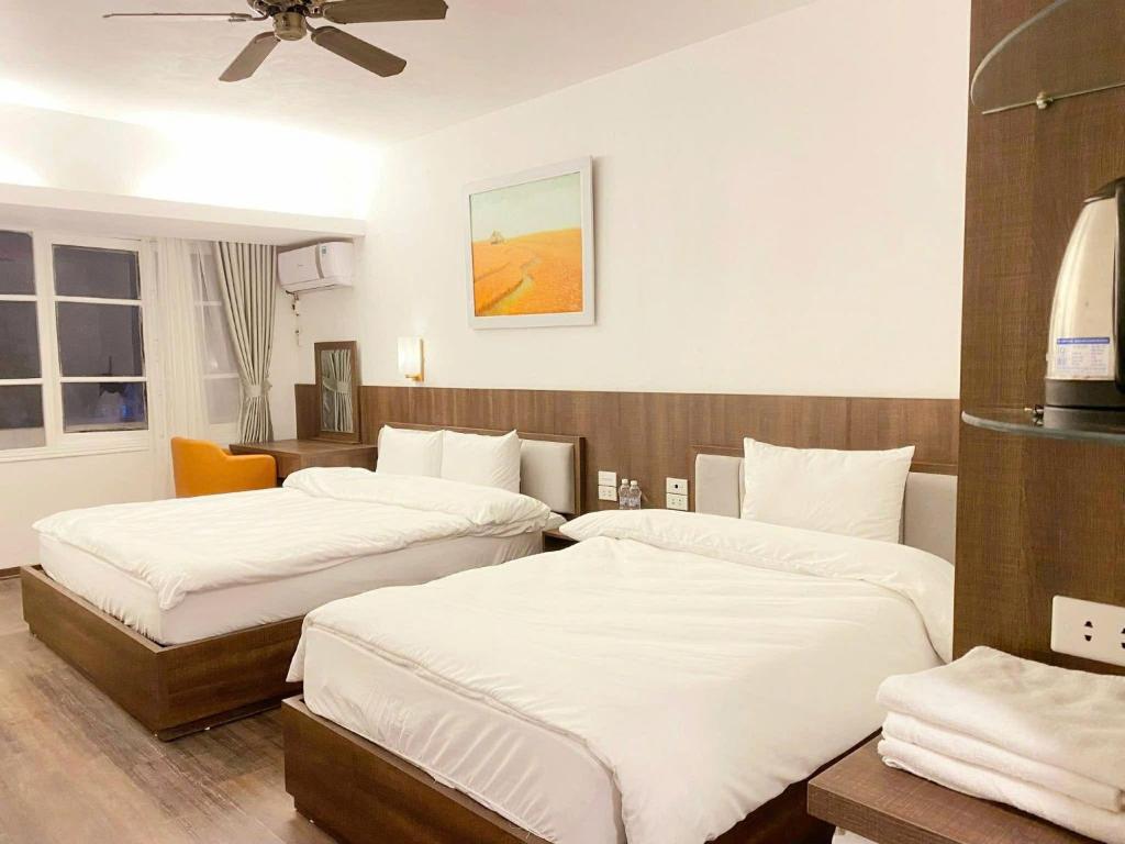 a bedroom with two beds with white sheets at Star Hotel - Khách sạn Ngôi Sao in Tam Ðảo