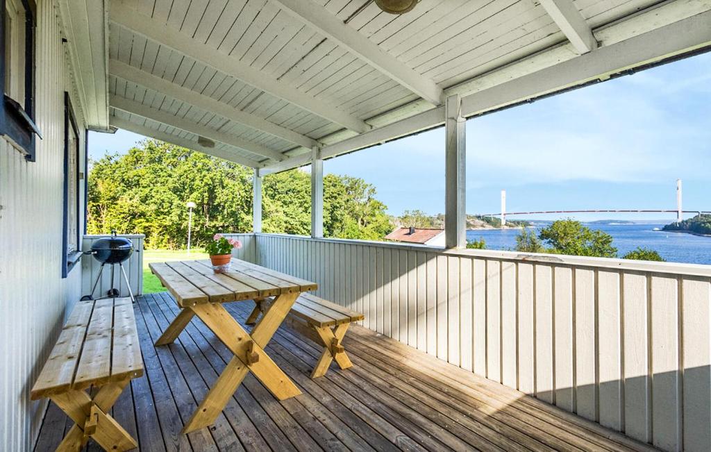 a picnic table on a deck with a view of the water at Lovely Home In Myggenäs With Sauna in Höviksnäs