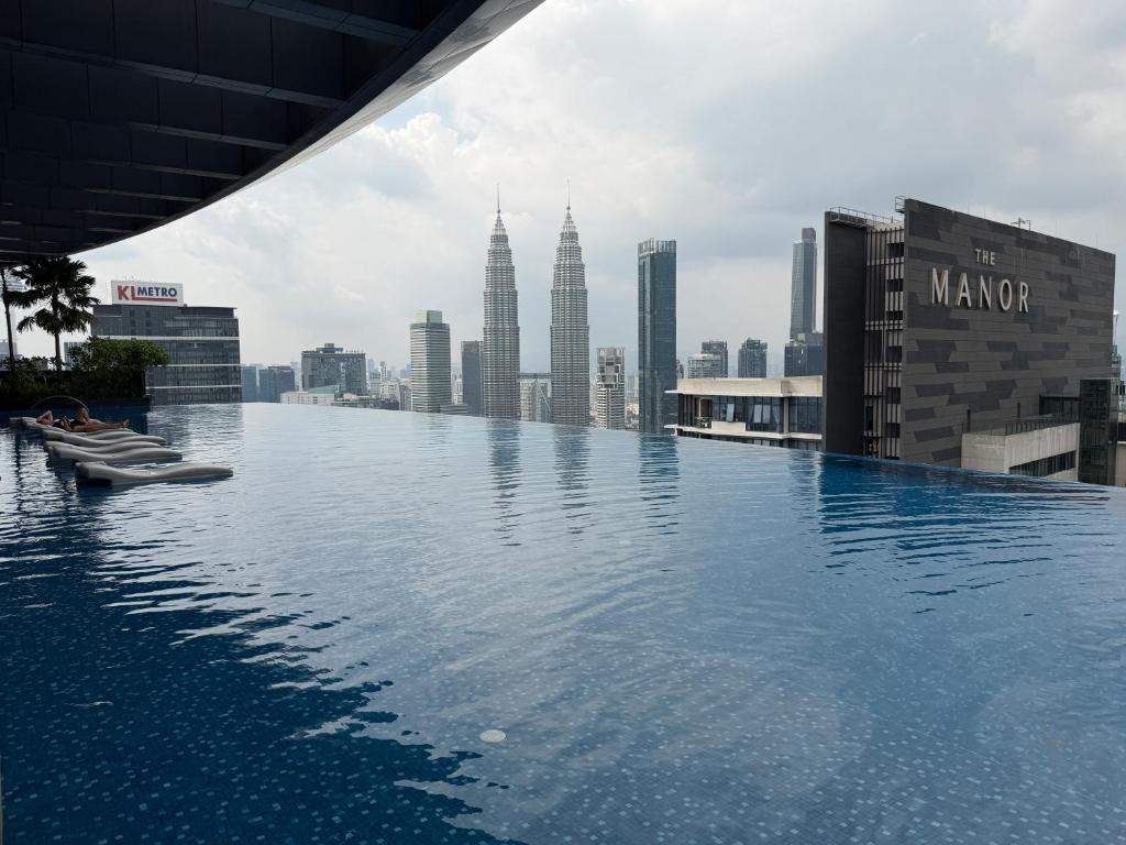 a infinity pool on the roof of a building with a city at Eaton Suites KLCC by Perkasa Ikon in Kuala Lumpur