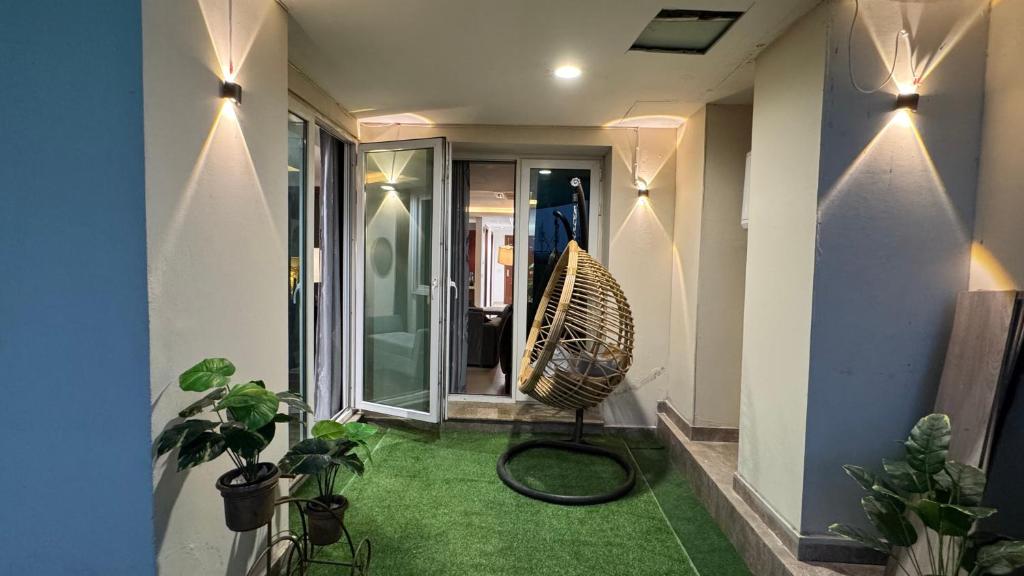 um corredor com uma cadeira e plantas em uma casa em Gold Crest Grand Apartments City View -DHA Phase 4 Lahore em Lahore