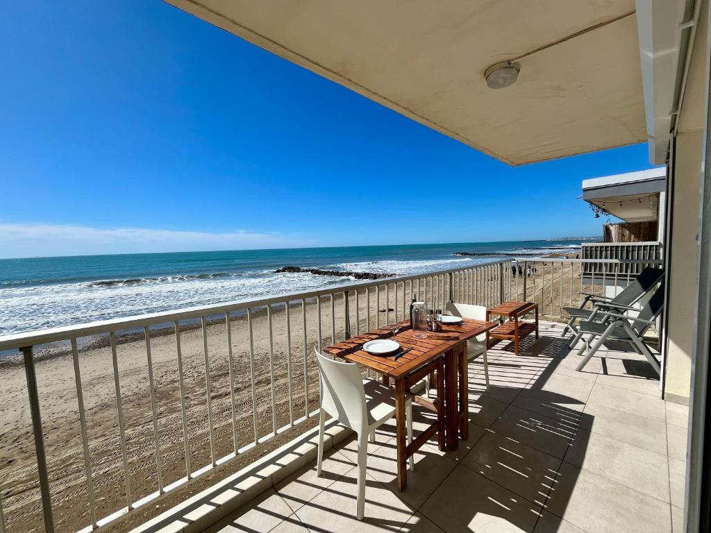 a balcony with a table and chairs on the beach at Palhawai - Appartement 2 chambres avec terrasse, parking et vue mer panoramique in Palavas-les-Flots