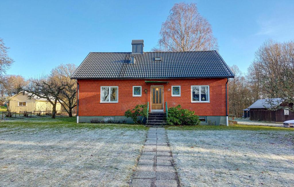 a red house with a black roof on a field at Nice Home In Bolmsö With Lake View in Bolmsö