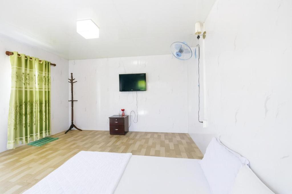 a room with a bed and a television on a wall at TRUNG LUONG HOMESTAY in My Tho