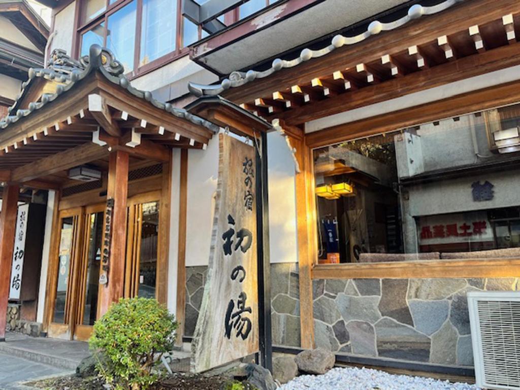 un ingresso di un edificio con una scritta asiatica sopra di Hatsunoyu a Yamanouchi