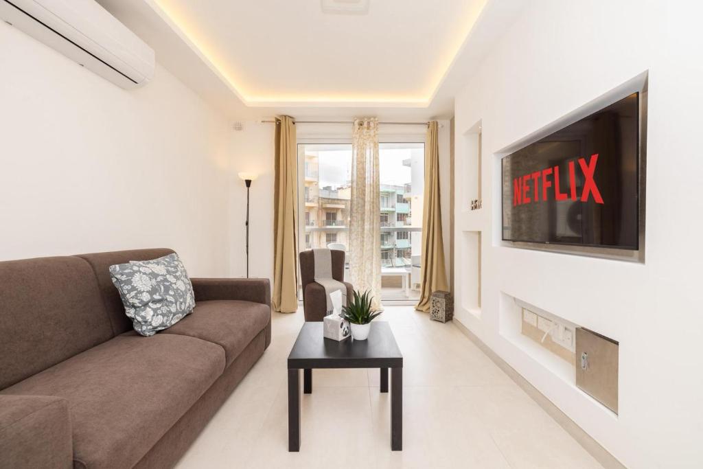a living room with a couch and a tv at Elmswater court in St. Paul's Bay
