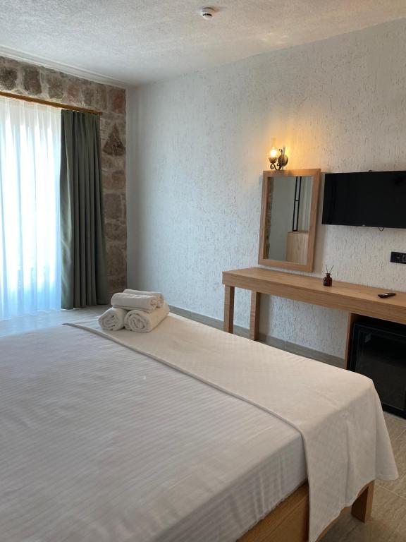 une chambre avec un grand lit blanc avec un miroir dans l'établissement Perlina Küçükköy, à Ayvalık