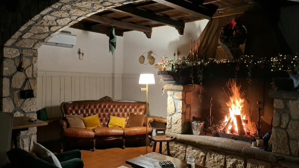 La Foresteria di Podere Muracciolo في توسكانيا: غرفة معيشة مع أريكة ومدفأة