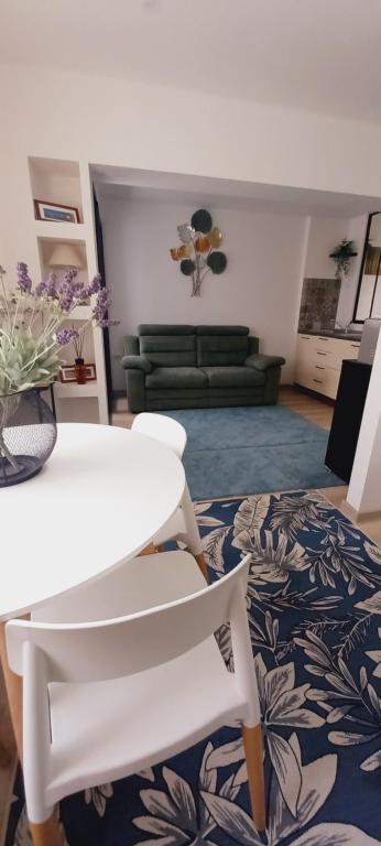 a living room with a white table and chairs at Studiou Elena in Lupeni