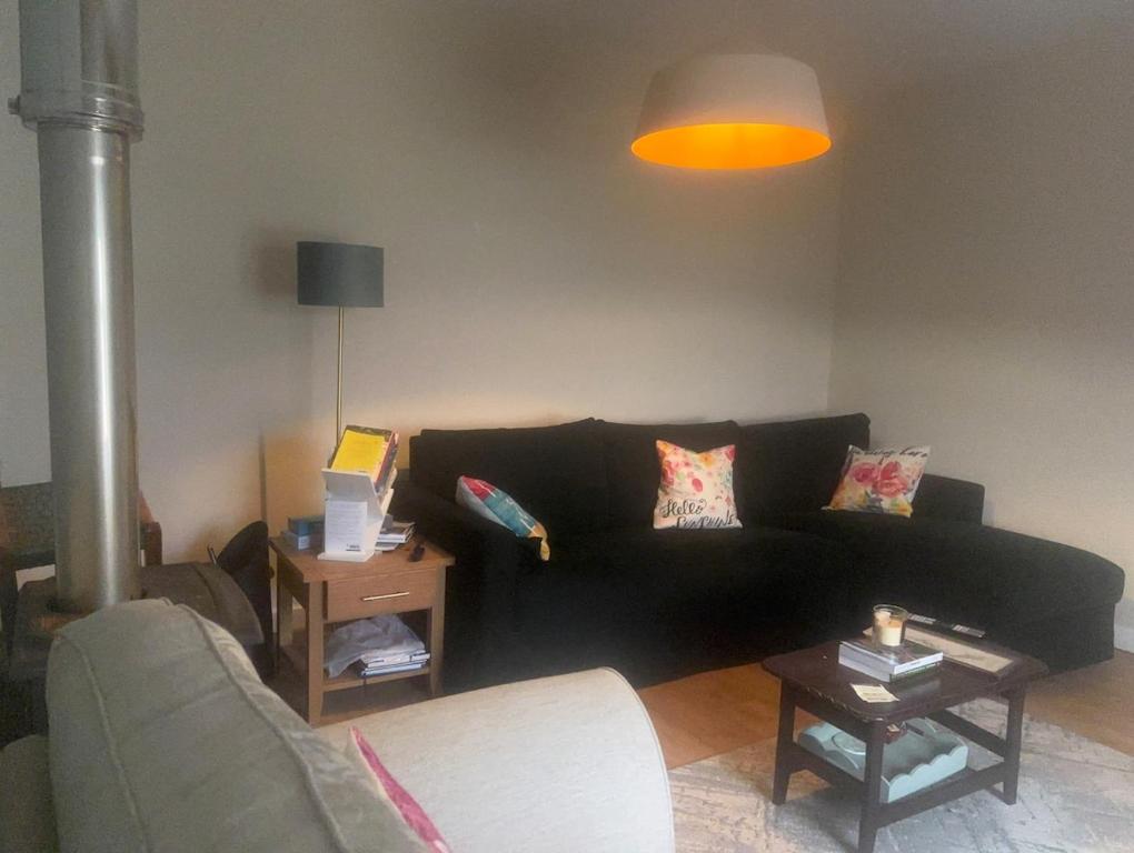 a living room with a black couch and a lamp at 3 bed house with stunning views on Achill Island in Sraheens