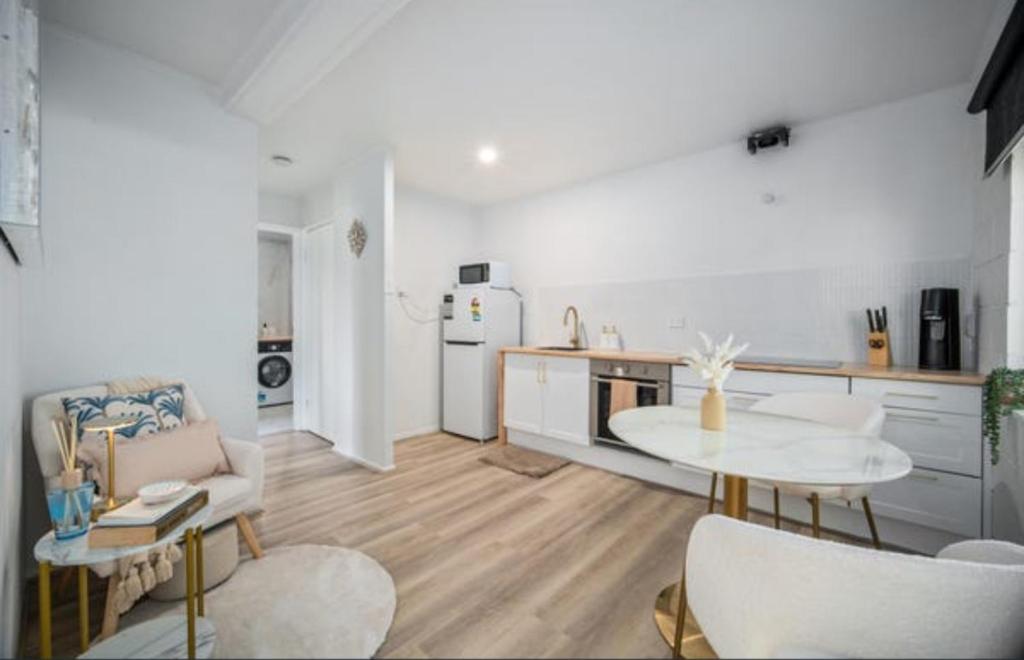 Boutique home in the heart of Surfers Paradise في غولد كوست: غرفة معيشة بها طاولة ومطبخ