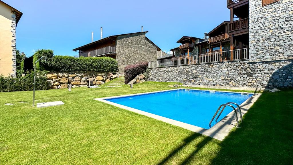 a swimming pool in a yard next to a building at Cal Fontcitrana, casa de montaña in Llivia