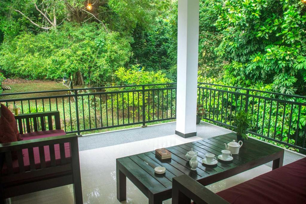 a porch with a table and chairs and a fence at Orange Jesmine Unawatuna in Unawatuna