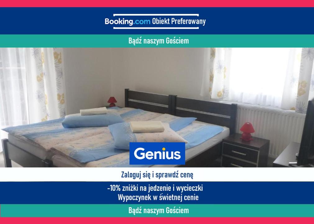Un sitio web de un dormitorio con una cama con almohadas azules. en Ośrodek Wypoczynkowy Nad Stawem vis a vis Parku Zdrojowego z Tężnią Solankową - B&B Holiday Resort By The Lake - Erholungsheim Am See - Prázdninový dům U Jezera, en Kudowa-Zdrój