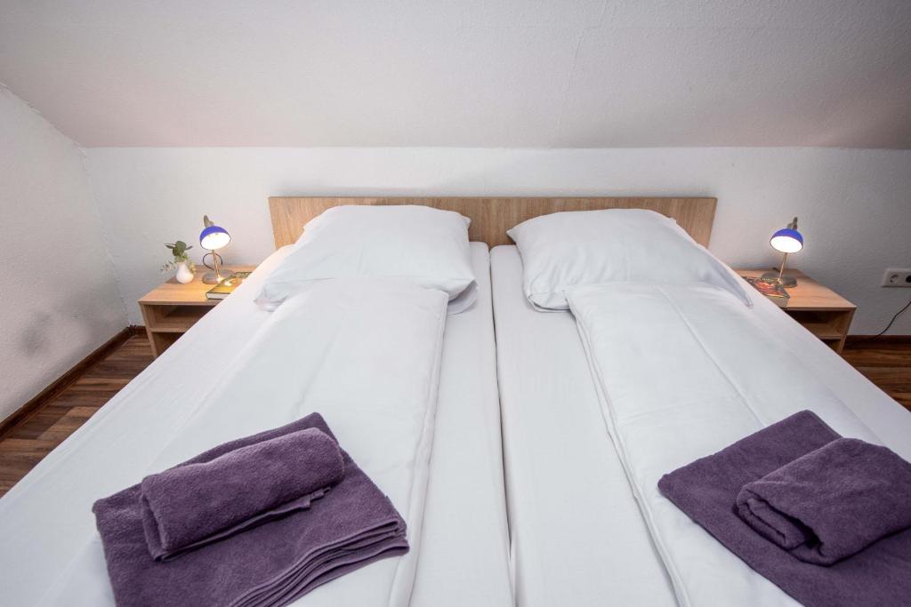 two beds in a room with purple towels at Ferienwohnung Auster in Manslagt