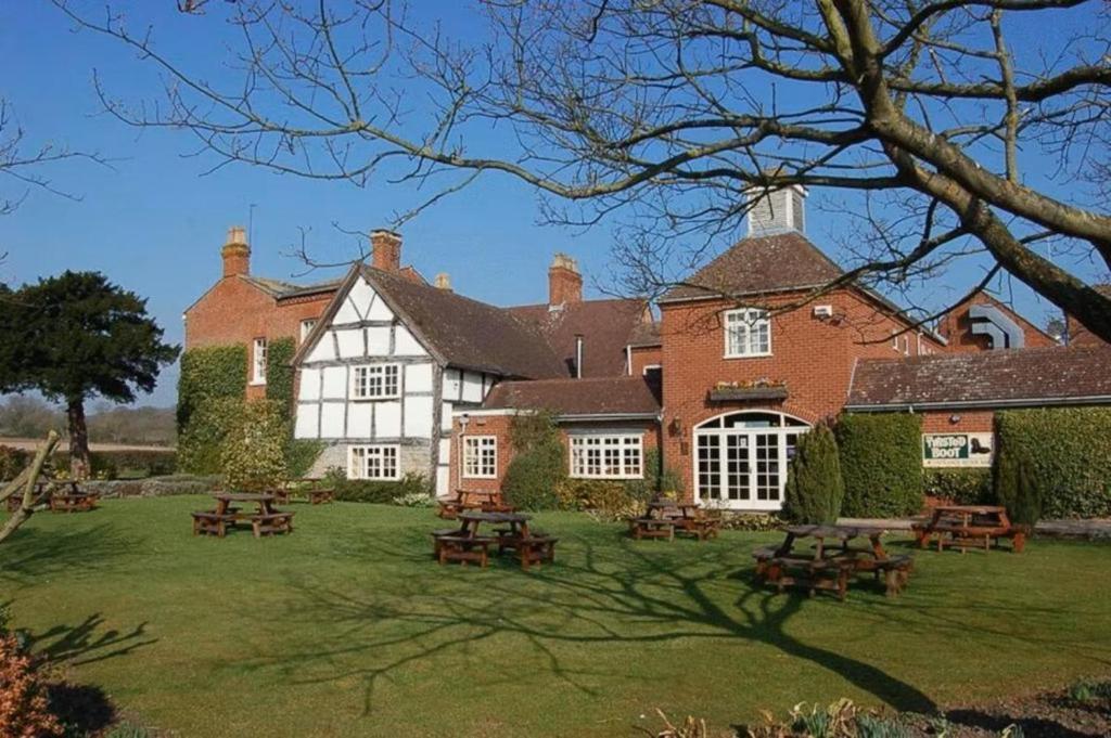 a large house with picnic tables in the yard at Kings Court Hotel Alcester, BW Signature Collection in Stratford-upon-Avon
