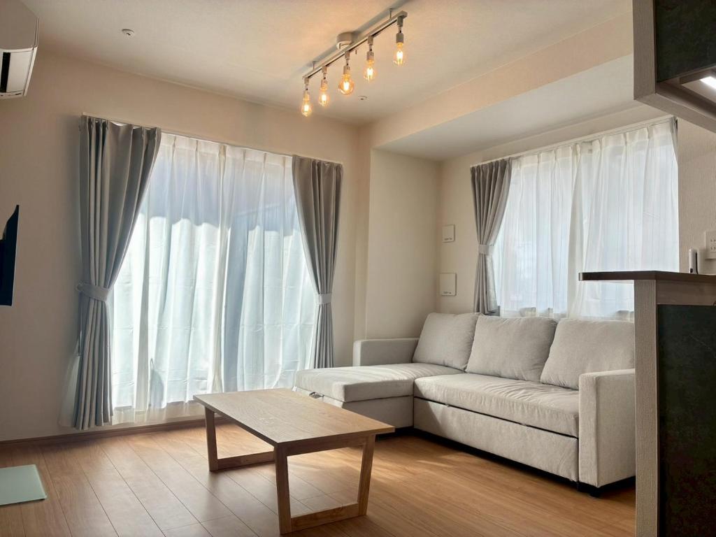 ein Wohnzimmer mit Sofa und Tisch in der Unterkunft In time tokyo in Ichikawa