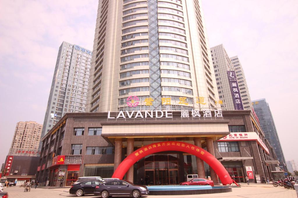 un gran edificio con un arco rojo delante de él en Lavande Hotel Nanchang East Aixihu Subway station Branch, en Nanchang County