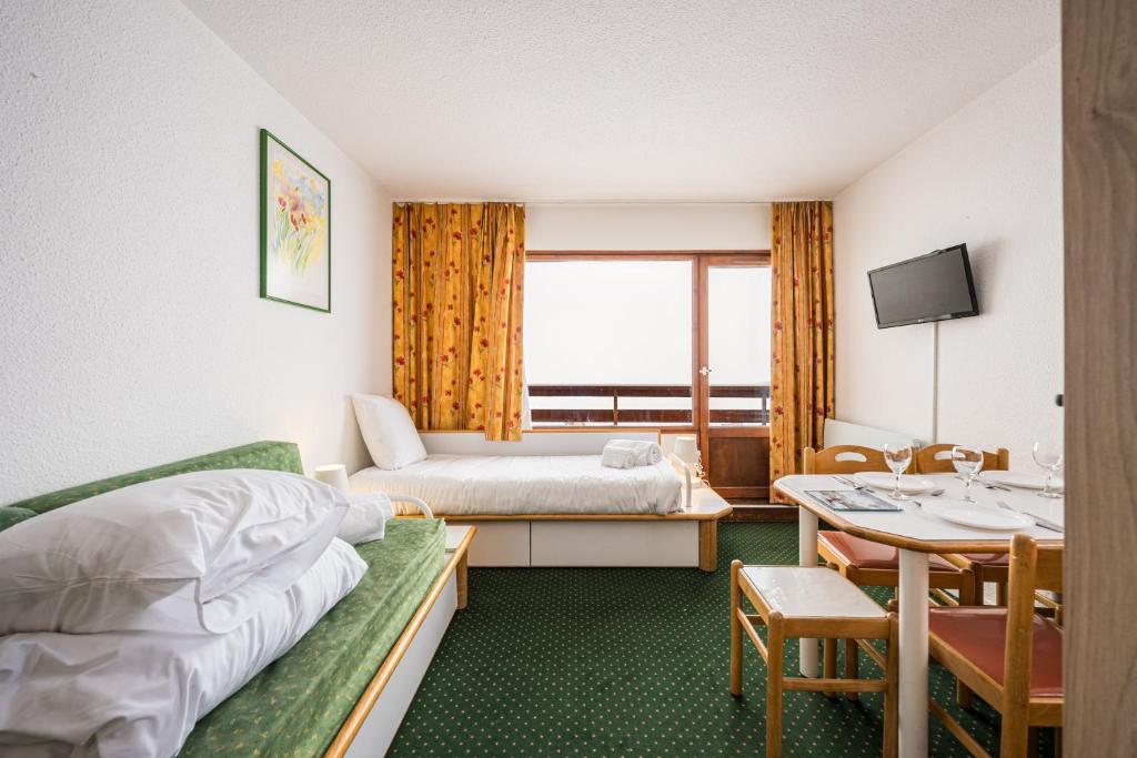 une chambre d'hôtel avec un lit et une table dans l'établissement Appartement Necou 105, aux Menuires