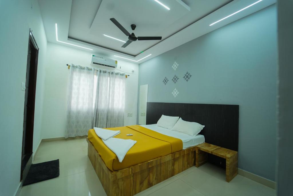a bedroom with a bed and a ceiling fan at Nandan Elite 3bhk in Mysore