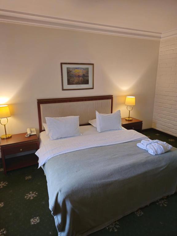 een groot bed in een hotelkamer met twee lampen bij Arien Plaza in Muruntau