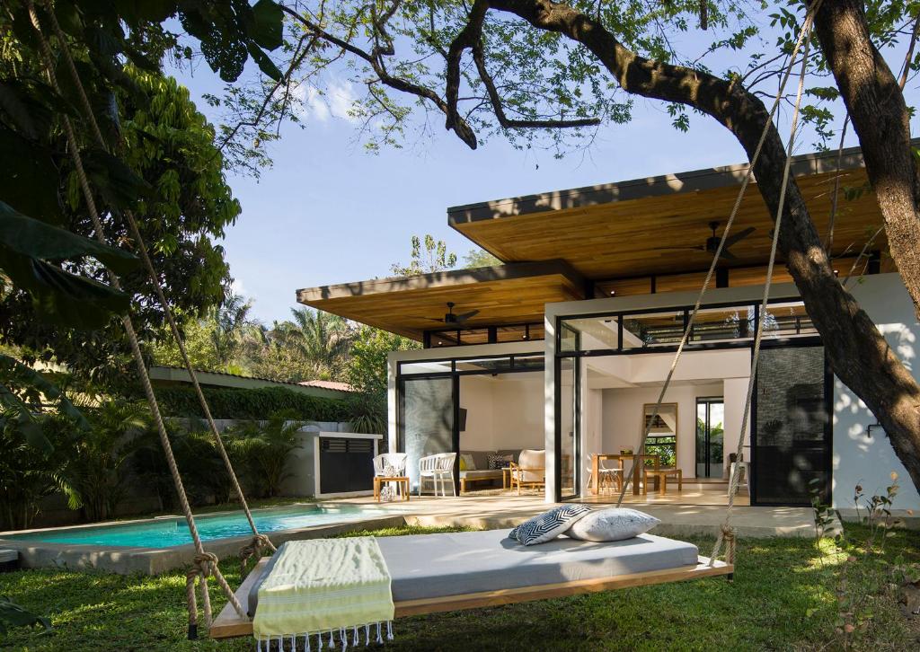 a swing bed in front of a house at Nalu Nosara Pool Villa Sombra in Nosara