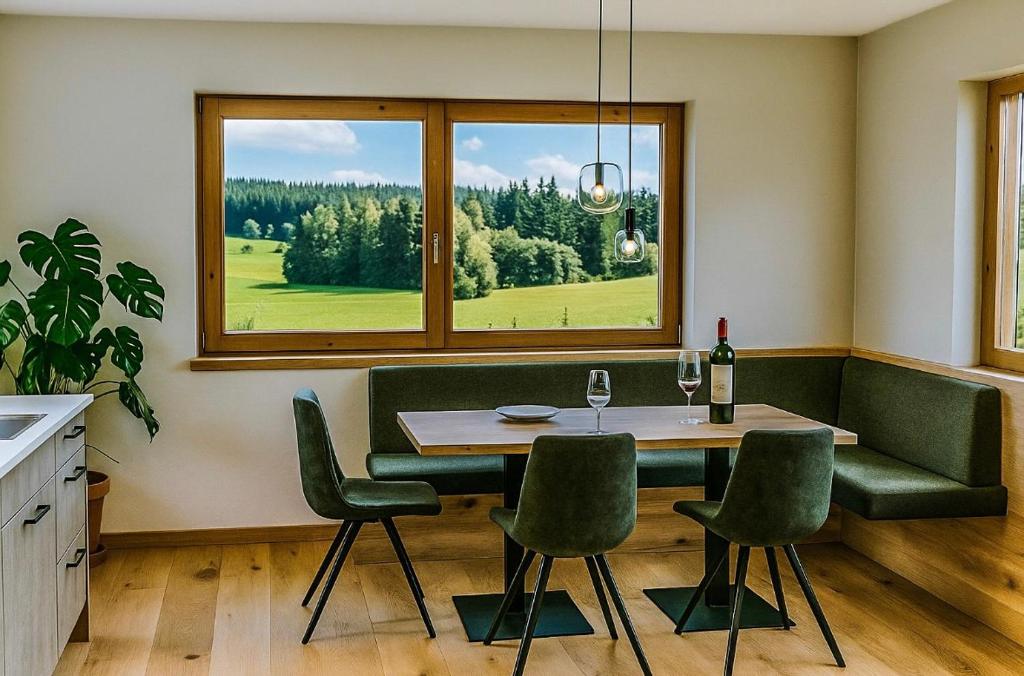 Un comedor con mesa y sillas y una ventana. en Hochthron Suites, 