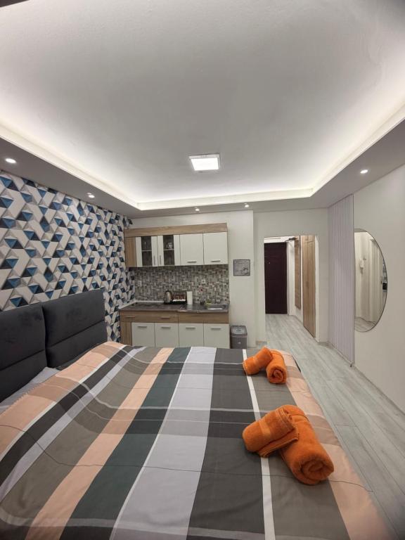 een slaapkamer met een groot bed en een keuken bij Central Square Apartment in Skopje