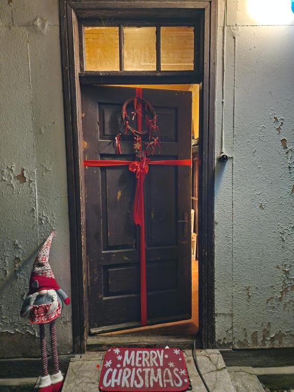 a christmas door with a merry christmas sign in front at Siedlisko pod starą lipą in Krzczonów-Wójtostwo