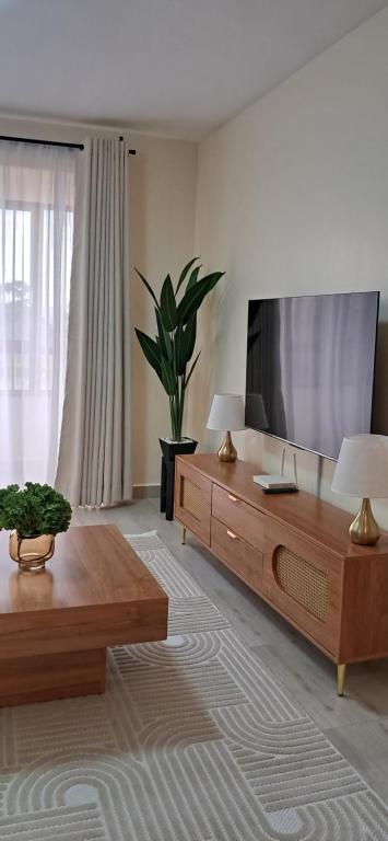 uma sala de estar com uma televisão de ecrã plano e uma mesa de centro em Lake View House- Shawmut Nakuru em Nakuru