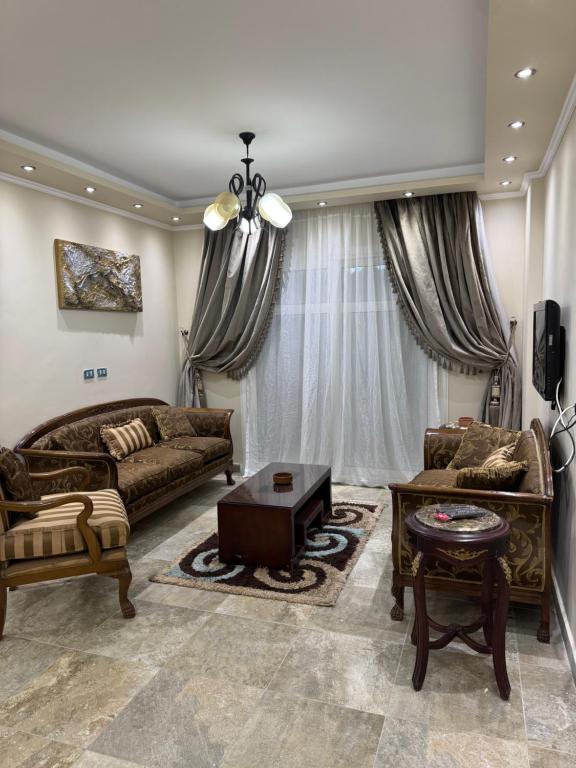 a living room with two couches and a table at Privado Modern Apartment Garden View B11 Group114 2BR in Madinaty