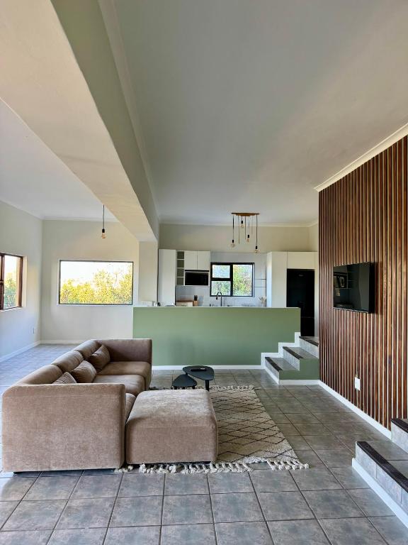 a living room with a couch and a kitchen at Sea and Vlei on Disa in Bettyʼs Bay